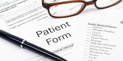 Medical patient form with glasses and pen